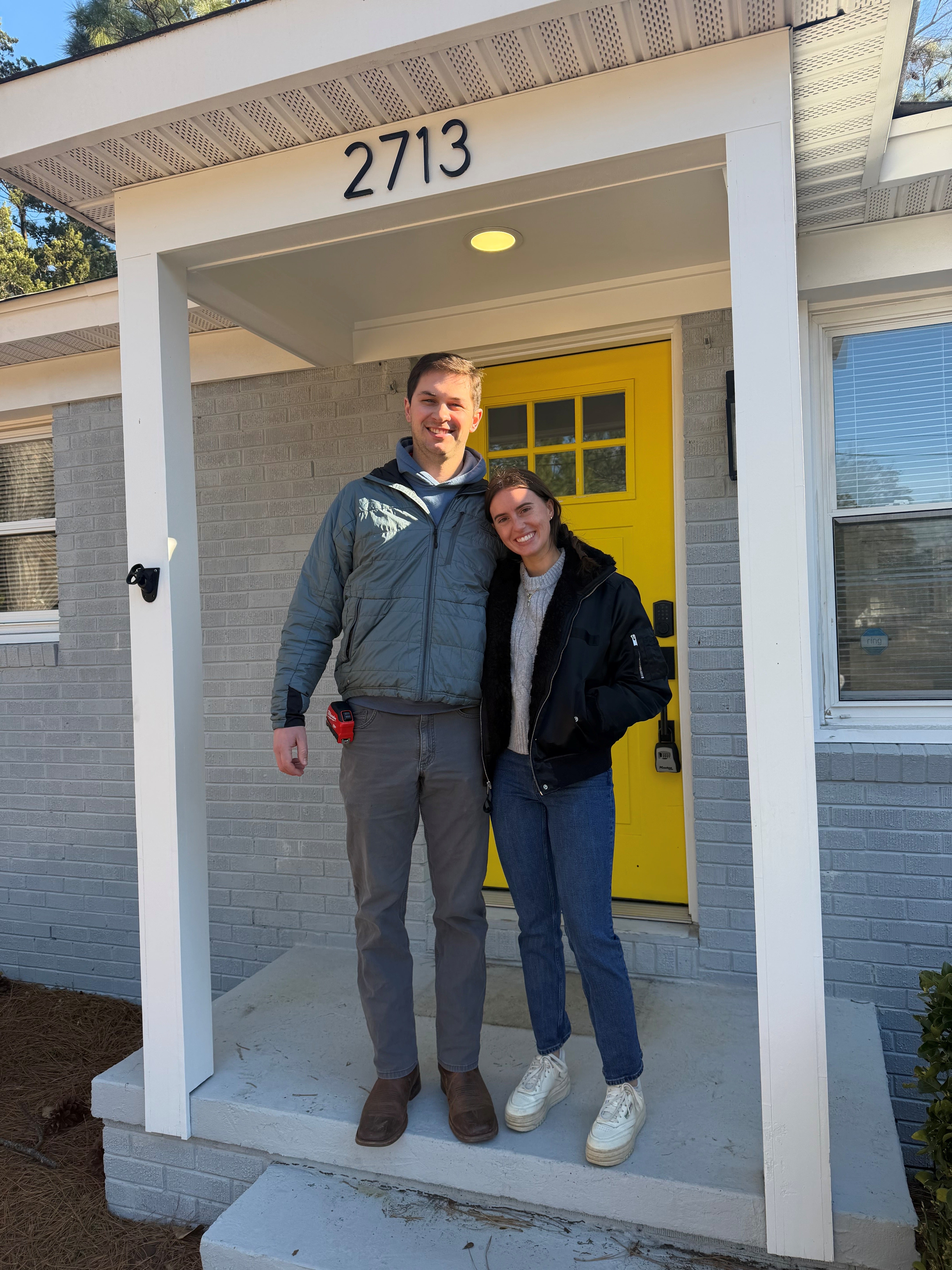couple standing in front of their house