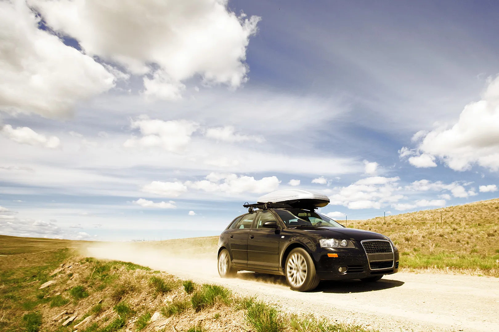 black car driving on gravel road