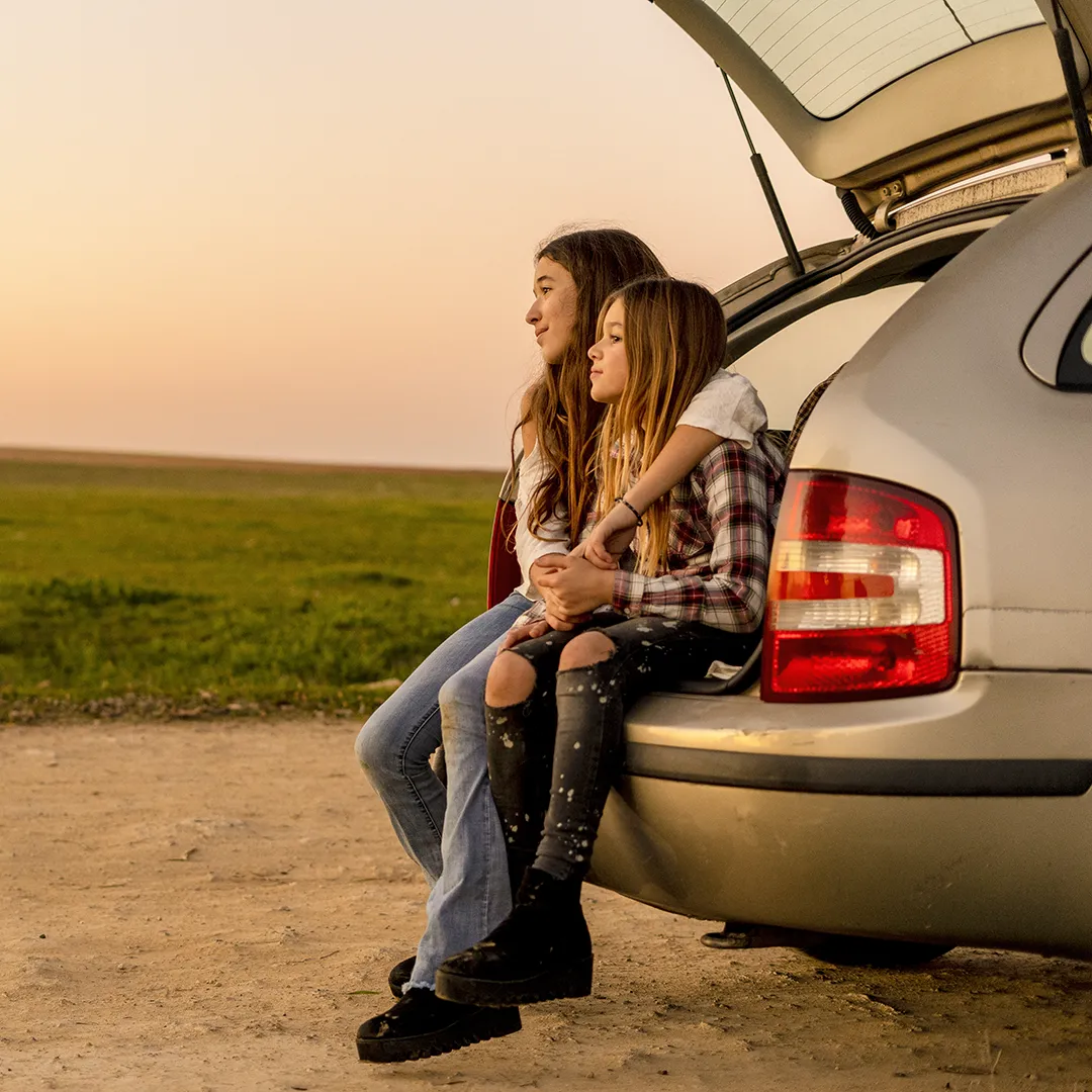 kids sitting in car trunk