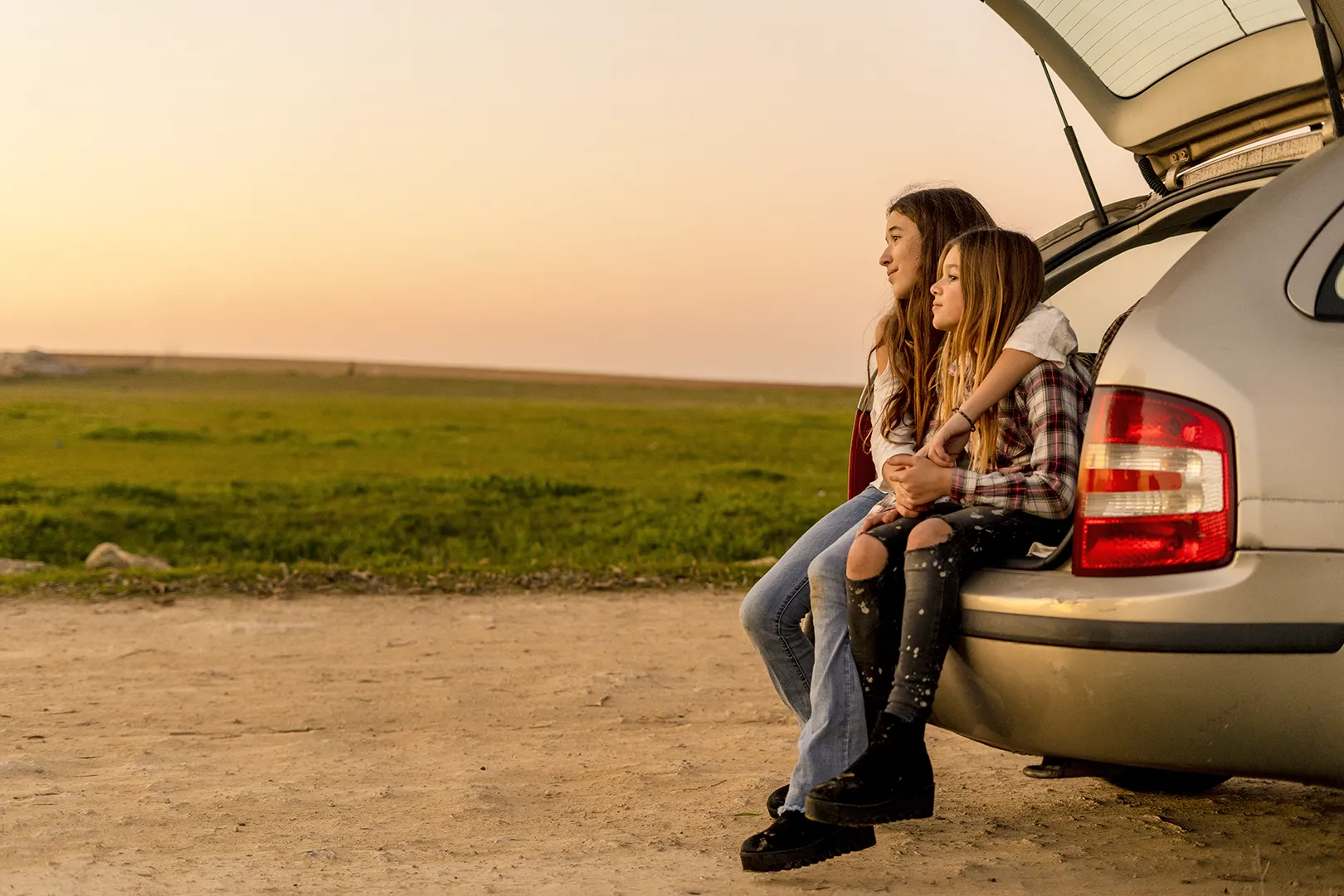 kids sitting in car trunk