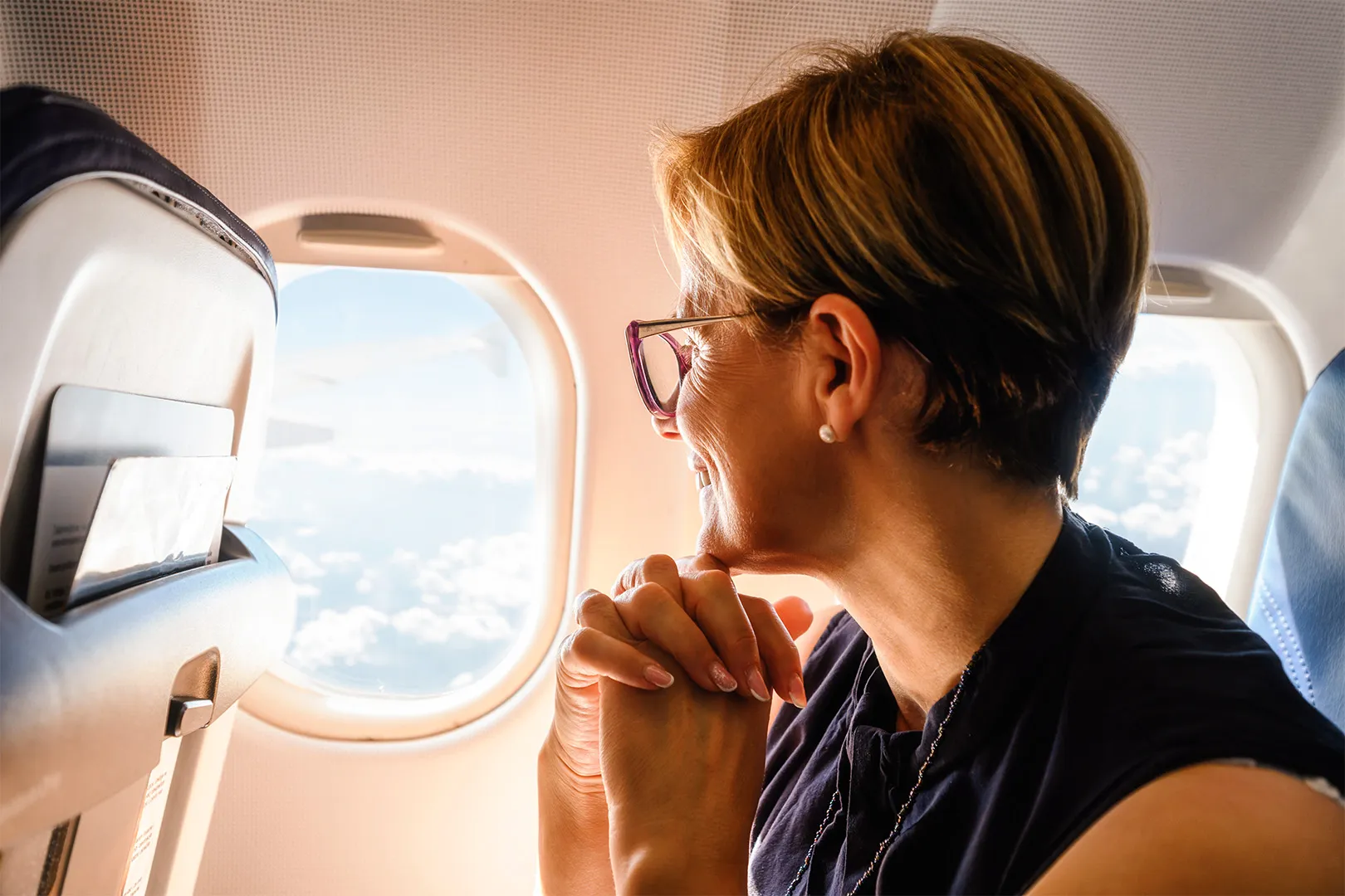 older woman looking out plan window