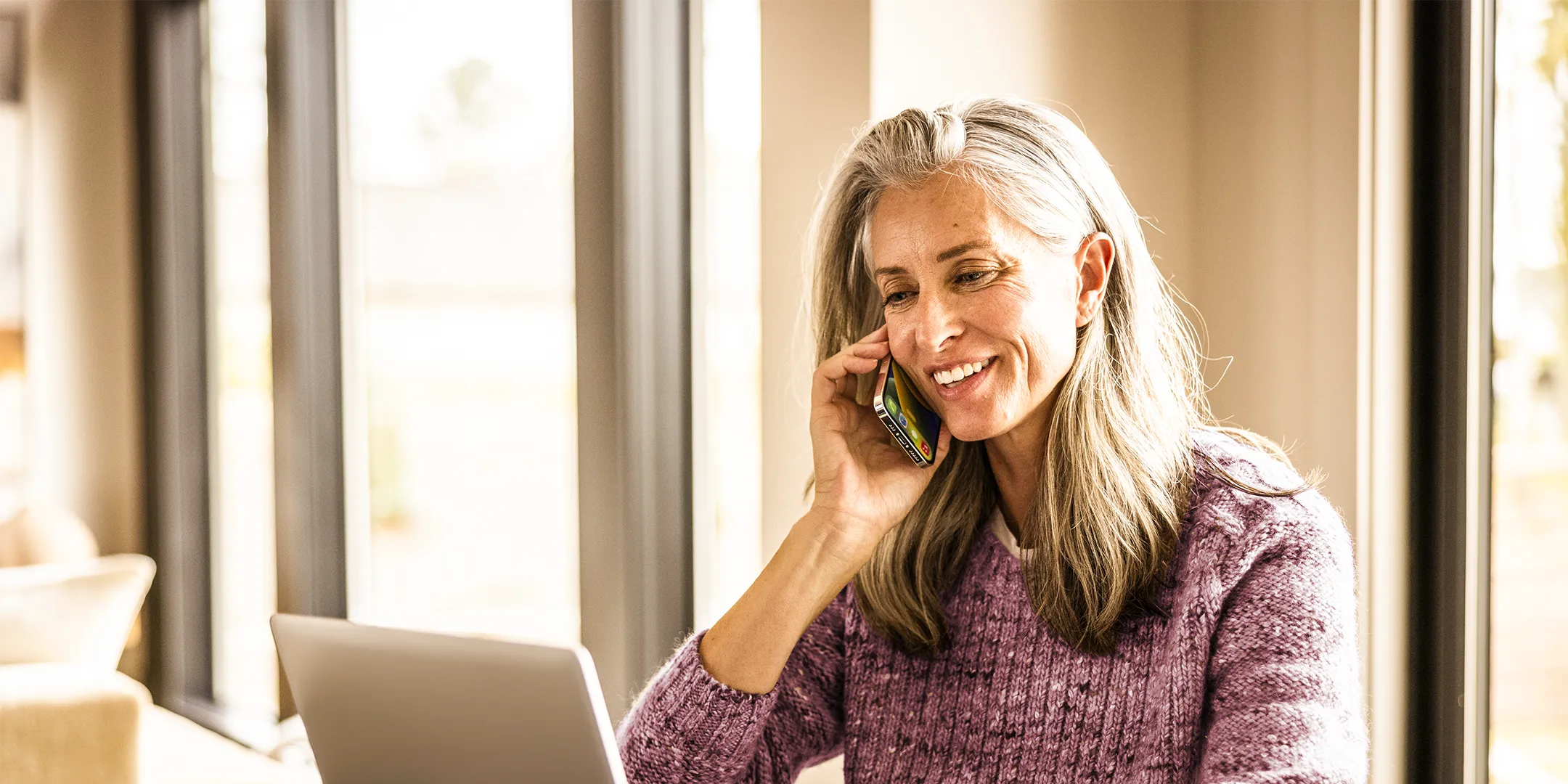 older woman on phone and laptop