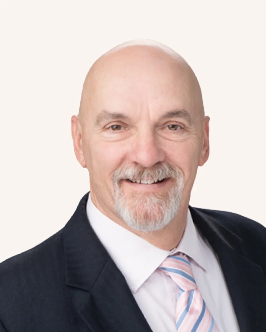 Headshot of a man smiling in a suit
