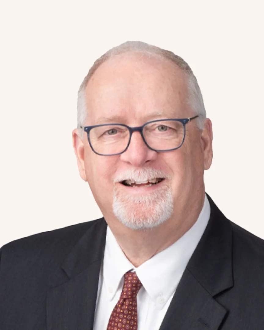 Headshot of a man smiling in a suit