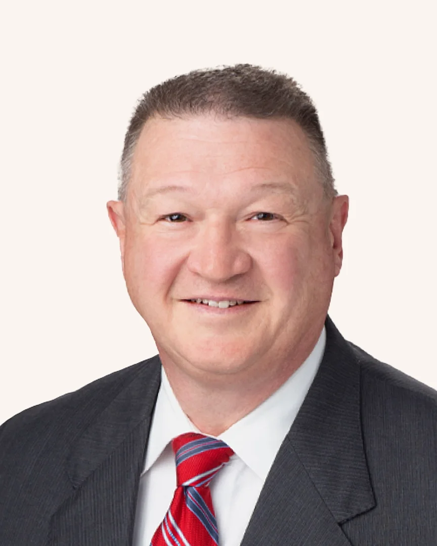 Headshot of a man smiling in a suit