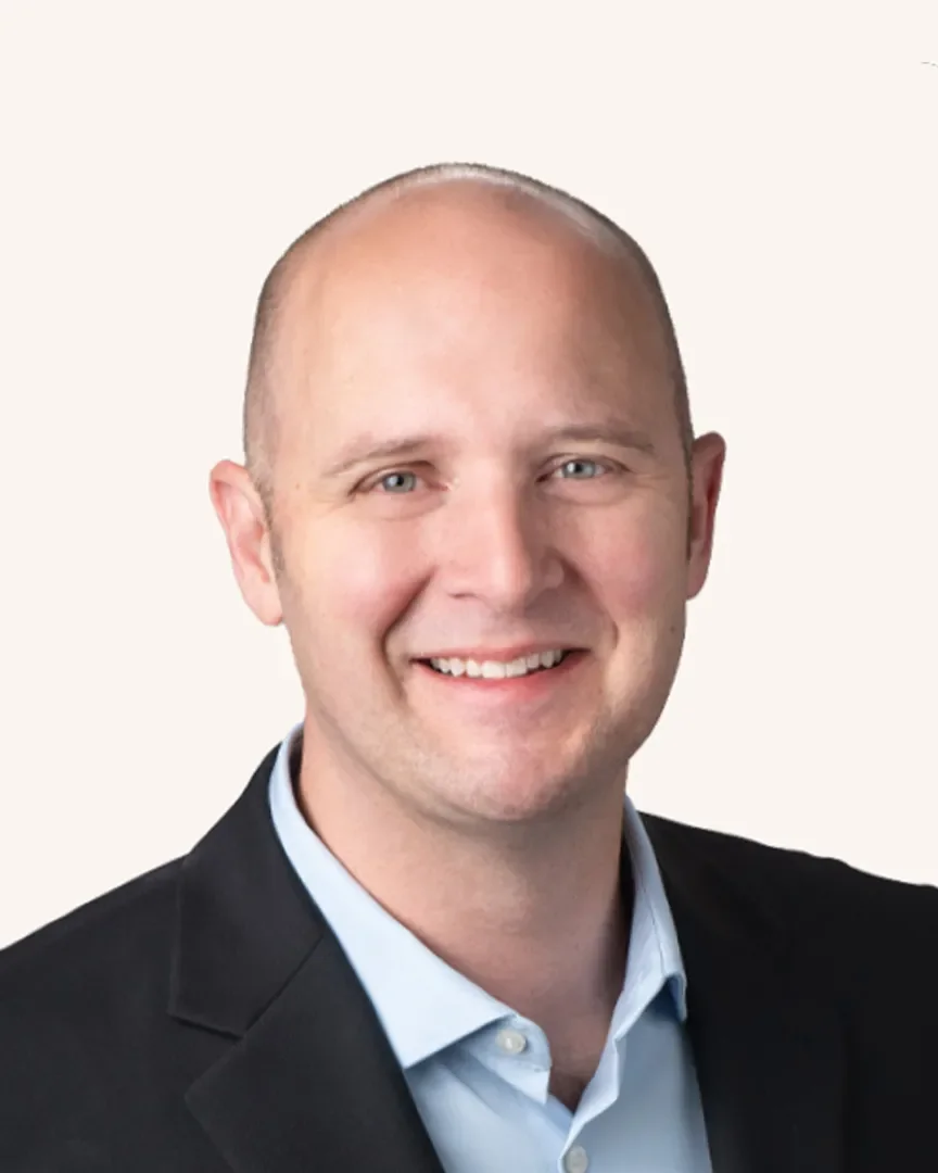 Headshot of a man smiling in a suit