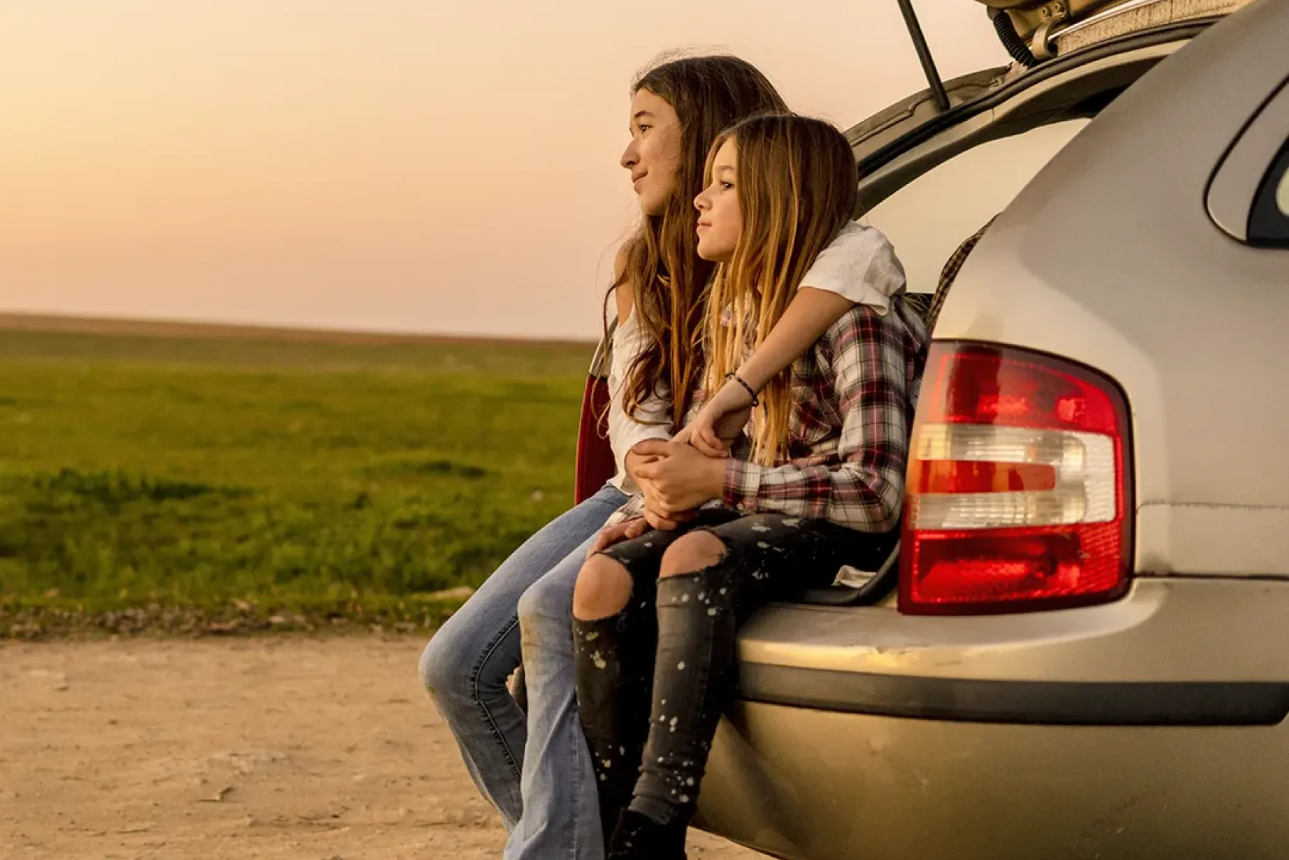 kids sitting in car trunk
