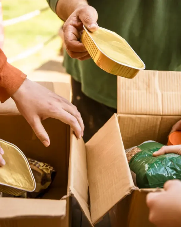 Hands grabbing food from cardboard boxes