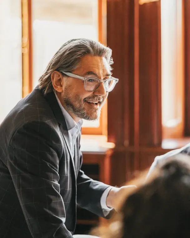 Man in suit smiling and talking during a business meeting
