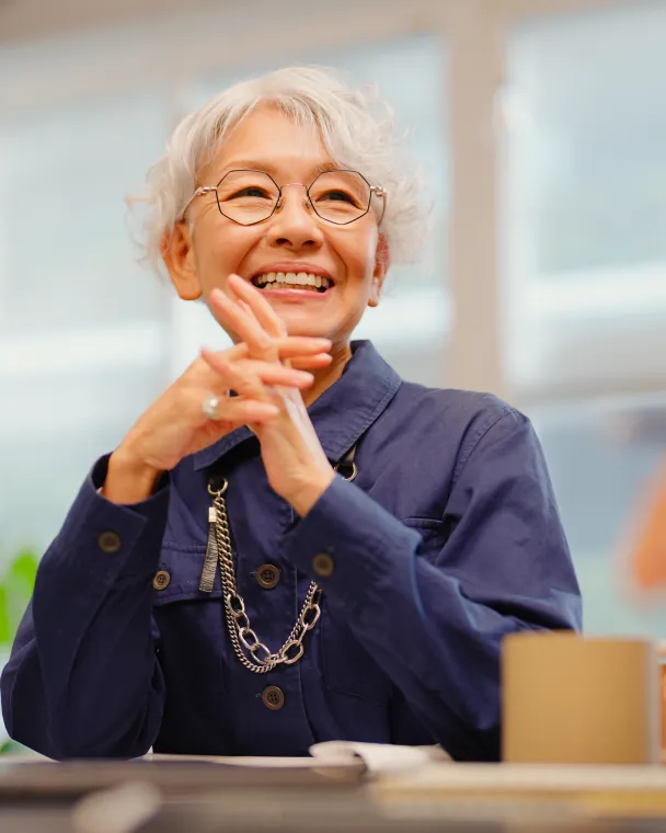 woman sitting at desk smiling having a consult