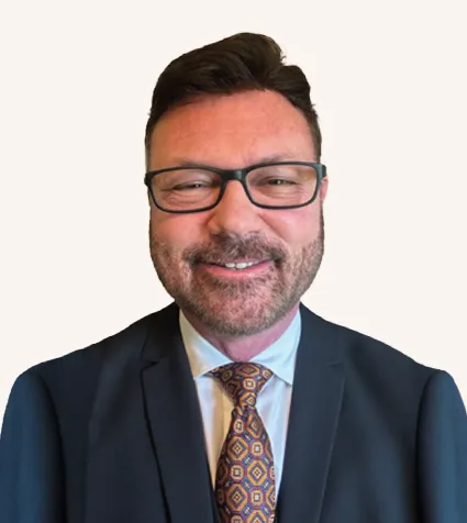 Headshot of a man smiling in a suit