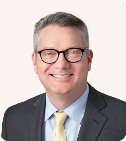 Headshot of a man smiling in a suit