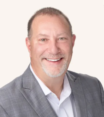 Headshot of a man smiling in a suit