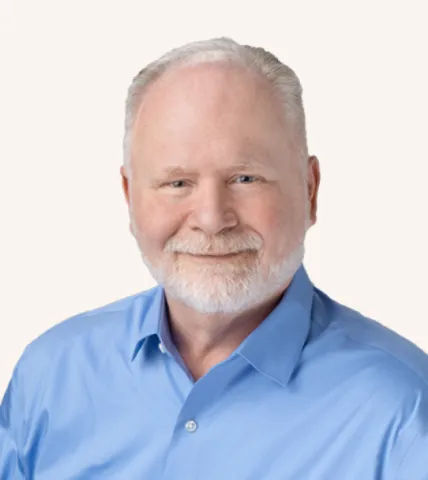 Headshot of a man smiling in a suit
