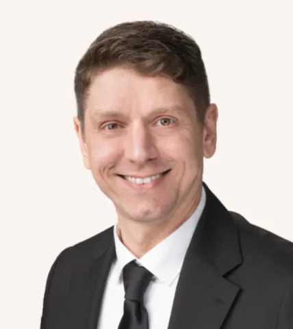 Headshot of a man smiling in a suit
