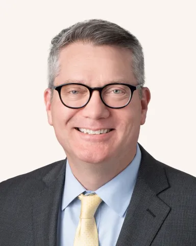 Headshot of a man smiling in a suit