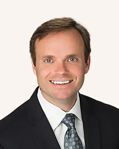 Headshot of a man smiling in a suit